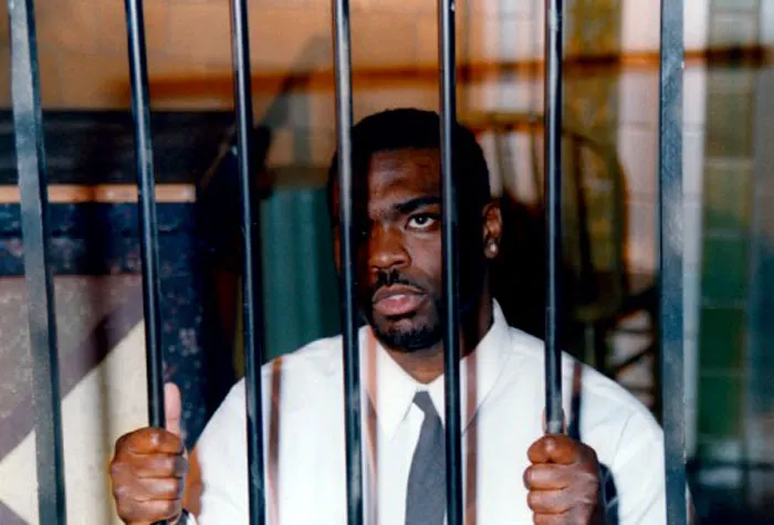 African American actor portraying a slave behind bars