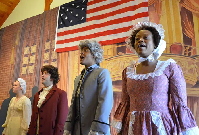 Actors in period piece outfits singing