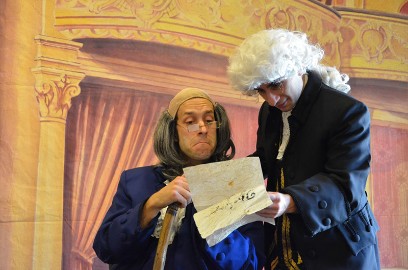 Two actors looking over declaration of independence